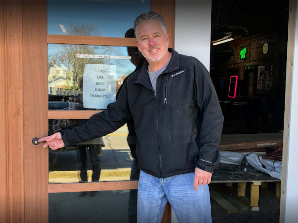 Palmetto Safe & Lock technician demonstrating a newly installed electronic access control system on a glass storefront door.